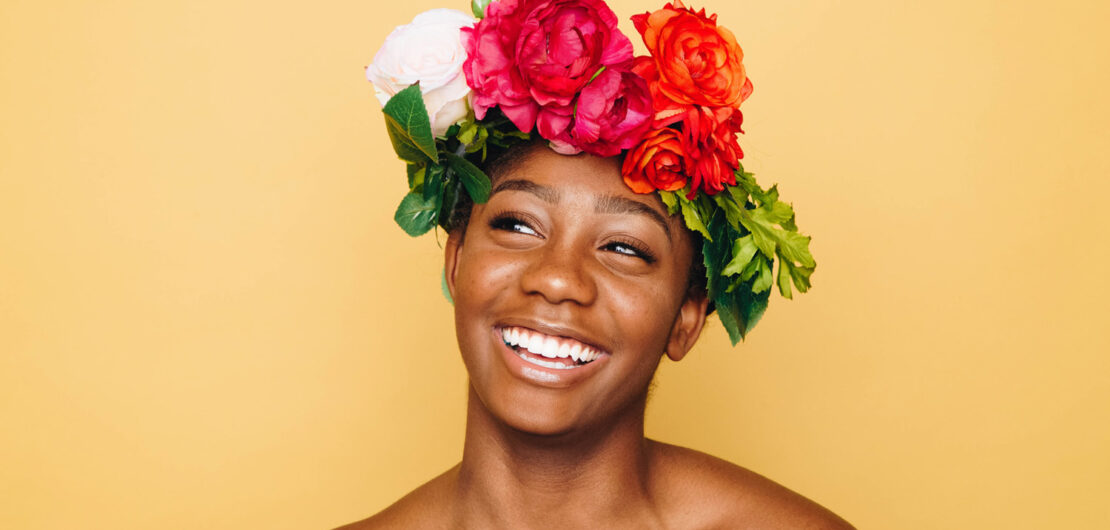 Glueckliche Frau mit Blumen im Haar Selbstbewusstsein und Selbstwertgefühl