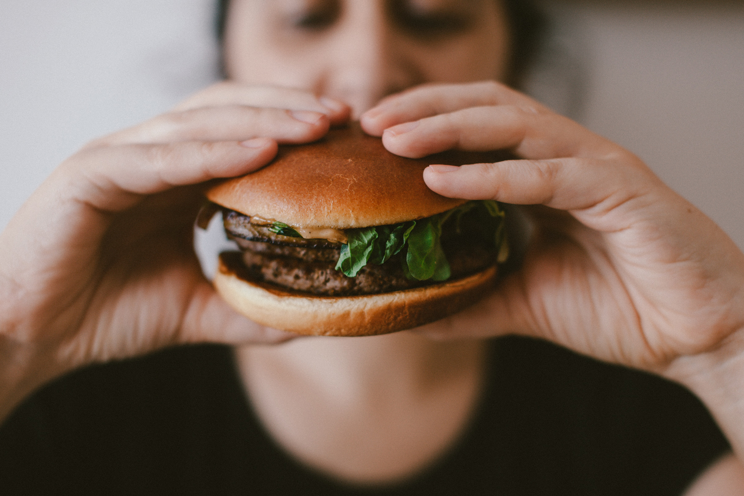 Person isst Hamburger, Essstörungen und Gewichtsreduktion